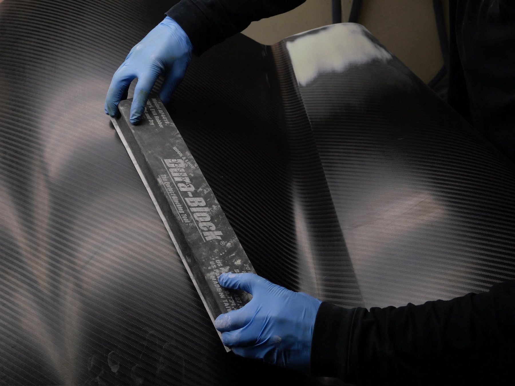 Carbon body panel being sanded — detailing and paintwork at DSS Studio